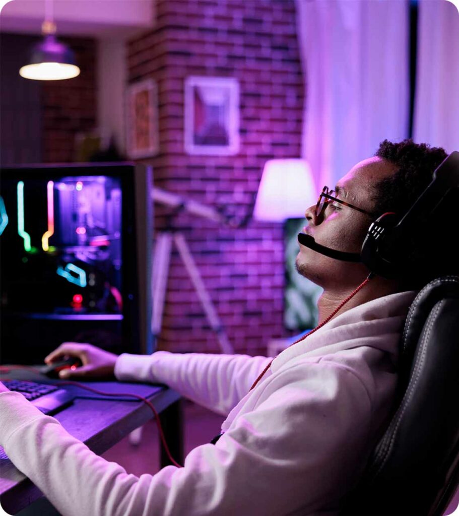 A boy with headphones in front of the pc