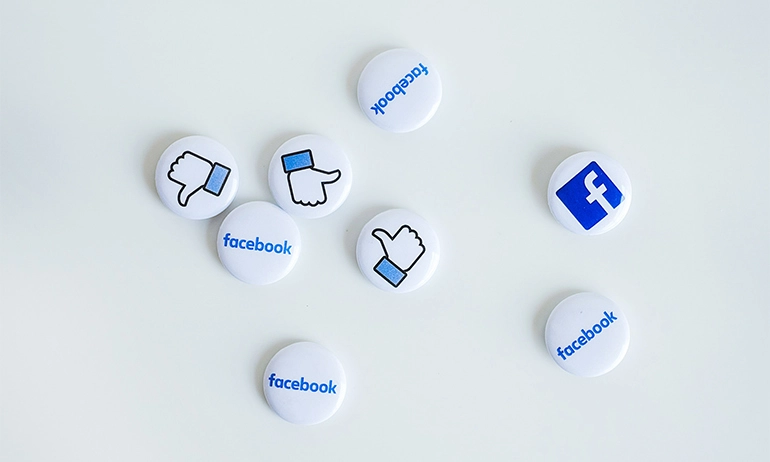 Several Facebook-themed buttons scattered on a white surface.