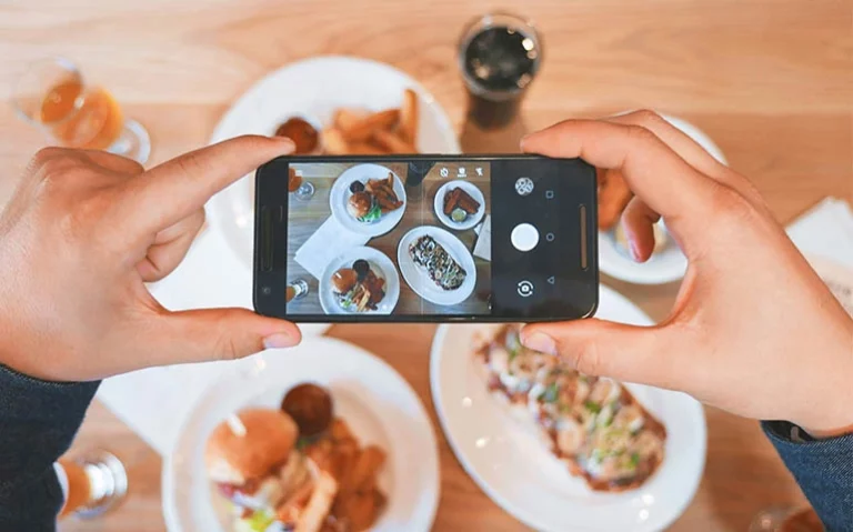 a phone taking pictures of their plate with food