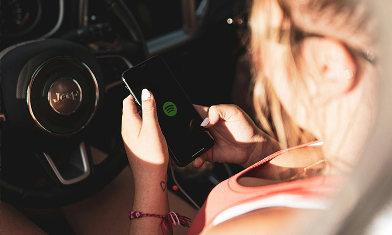 image of a girl using spotify while she is inside her car