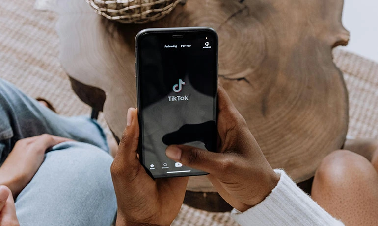 hands holding a phone while the TikTok account is opening.