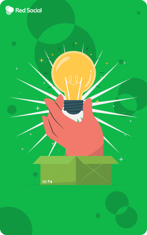 Hand holding a glowing lightbulb emerging from a box